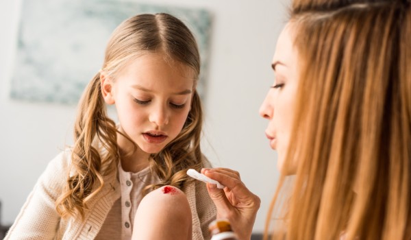 a mother attending to child's cut